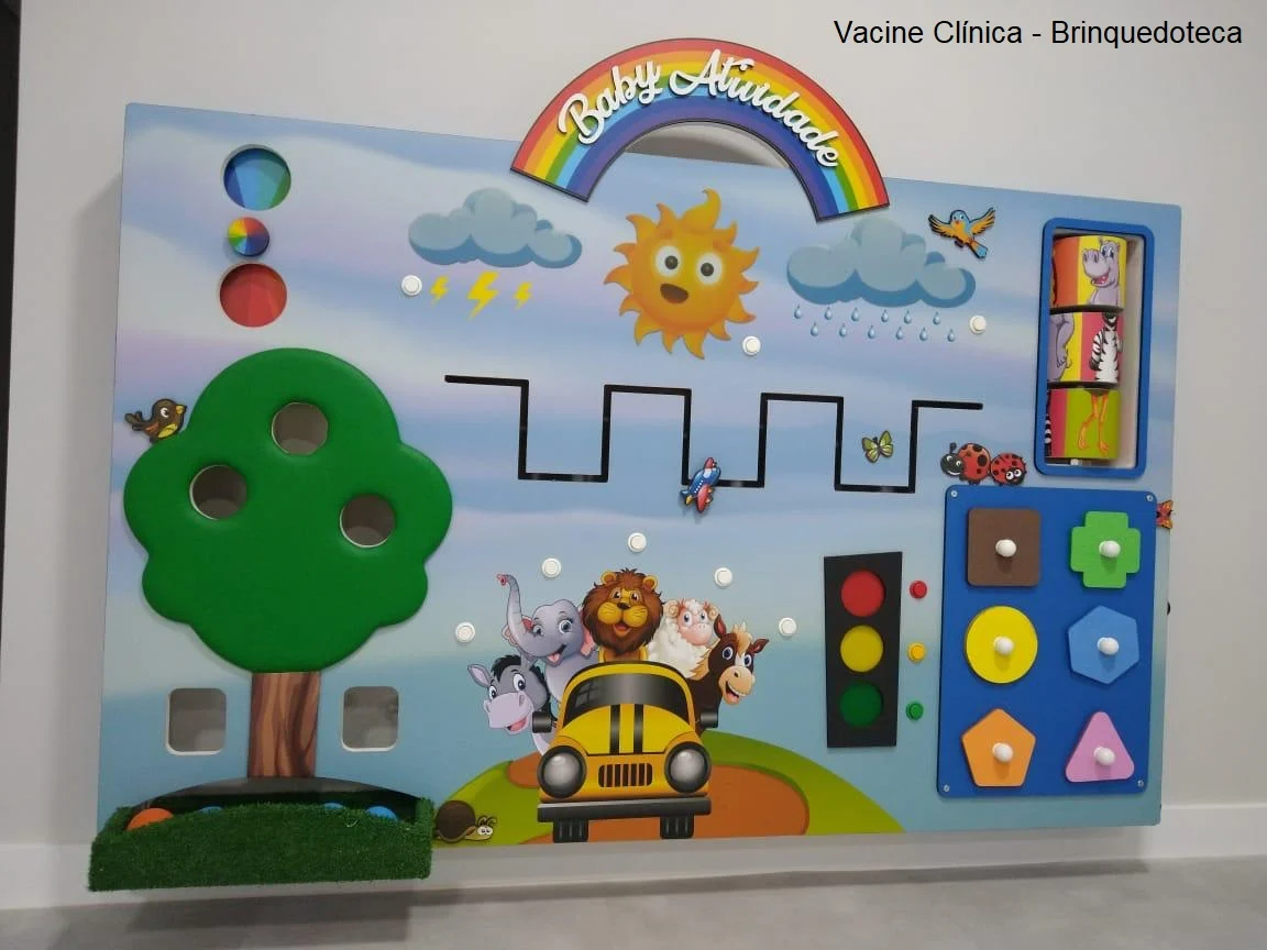 Painel de atividades colorido com arco-íris e brinquedos na clínica